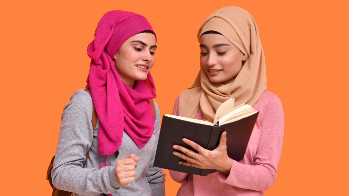 Two Hijabi girls reading book abroad